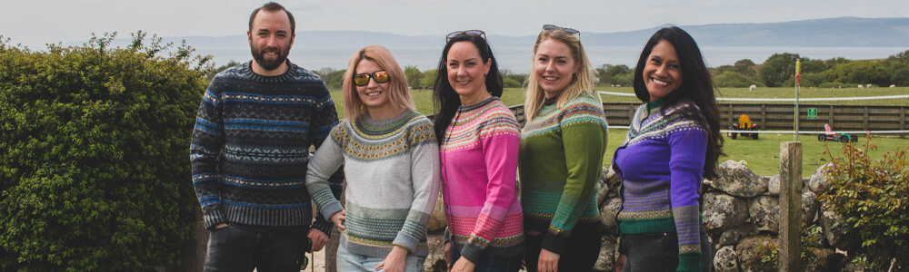 people standing facing camera wearing colourful knitwear jumprers from Eribe
